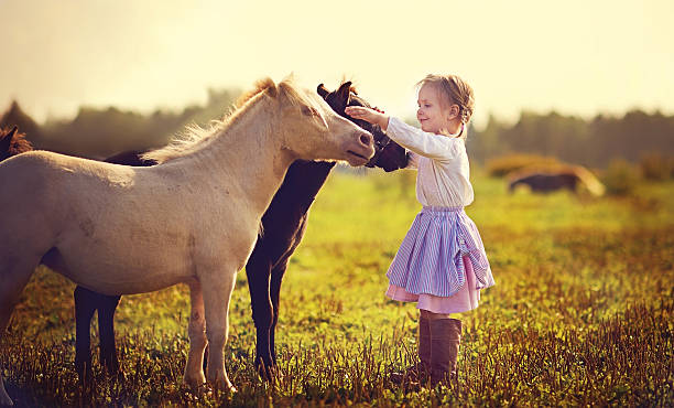 A tender portrait of a young girl with her hair in a messy bun, dressed in a white dress, hugging a gentle pony in a sunlit meadow. Nearby, small rustic cottages and a rabbit hutch add a charming countryside atmosphere to the scene.