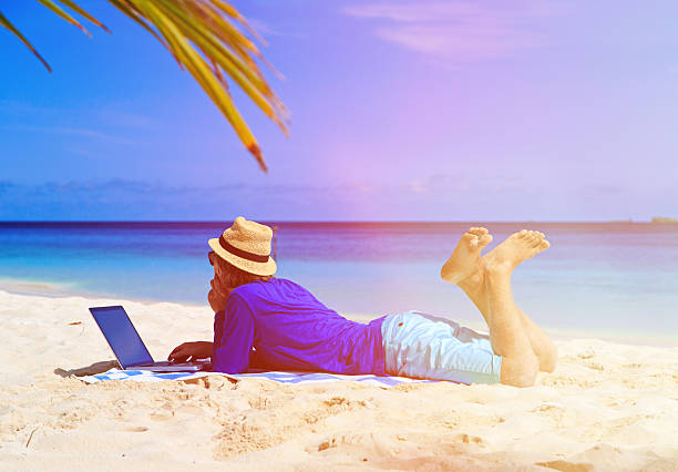 istock young man with laptop on tropical beach 486492232