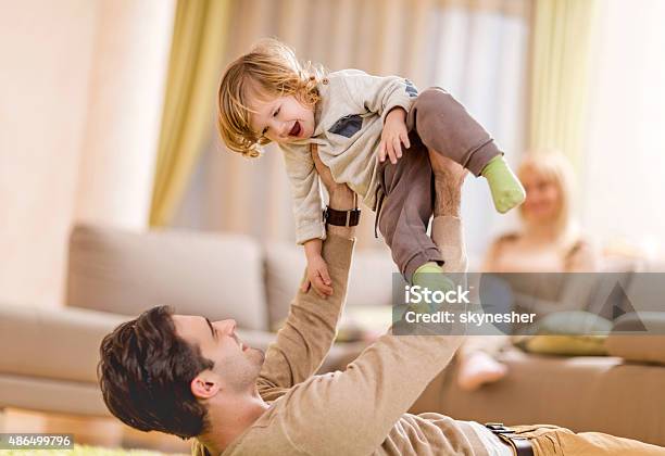 Cheerful Father And Son Playing At Home Stock Photo - Download Image Now - 2015, Adult, Bonding