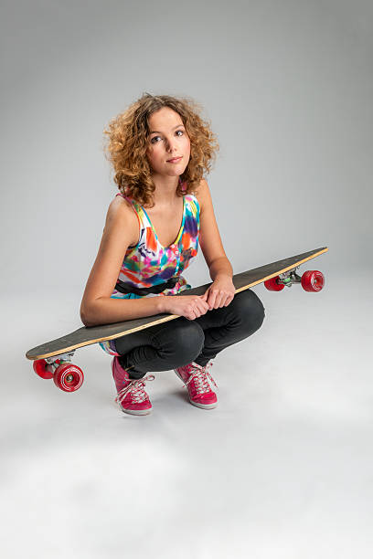 幸せな若い女性、pintail longboard 、スケートボード - kneeling skateboarding skateboard vertical ストックフォトと画像