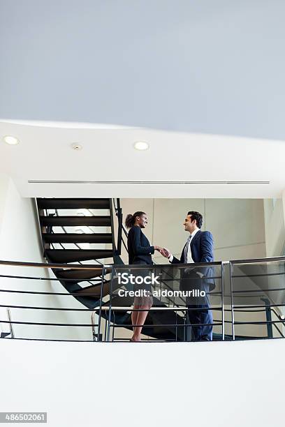 Business Partners Shaking Hands In Hallway Stock Photo - Download Image Now - Handshake, Staircase, CEO