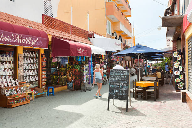 Tourist Market Street Hidalgo in Isla Mujeres by Cancun, Mexico Isla Mujeres, Mexico - April 16, 2014: Tourists and visitors enjoying the tourist district of the tropical island of Isla Mujeres. Isla Mujeres an island off of Cancun, a popular tourist destination along the Riviera Maya, Mexico. isla mujeres stock pictures, royalty-free photos & images