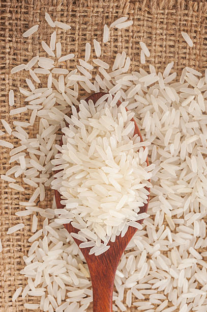 istock Rice, White rice in wooden spoon on a hemp sack 486505238