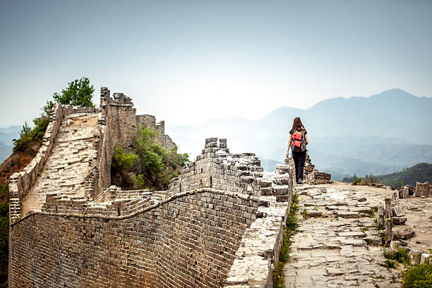 Solo Woman Tourist at Great Wall Of China Solo Woman Tourist at walking on the Great Wall Of China. She is wearing a backpack. great wall of china photos stock pictures, royalty-free photos & images