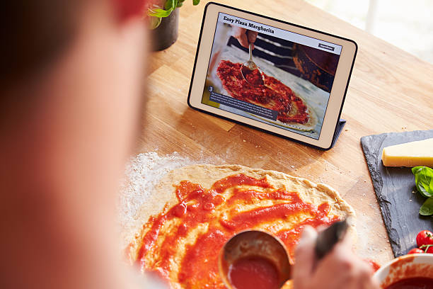 istock Person Following Pizza Recipe Using App On Digital Tablet 486506110