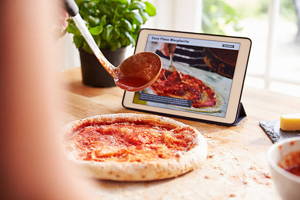 istock Person Following Pizza Recipe Using App On Digital Tablet 486506116