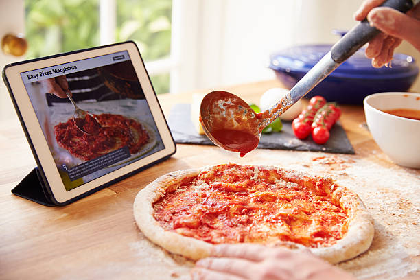 istock Person Following Pizza Recipe Using App On Digital Tablet 486506120