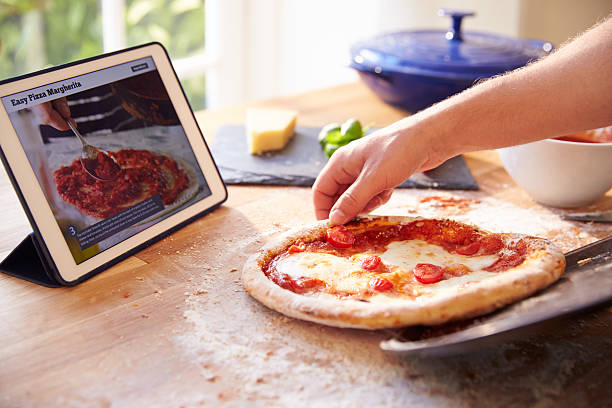 istock Person Following Pizza Recipe Using App On Digital Tablet 486506134