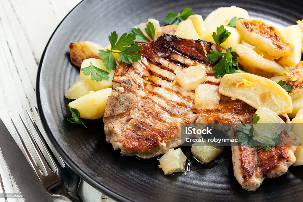 Pork Meal Grilled pork served with a potato, apple and lemon salad. Apple - Fruit Stock Photo