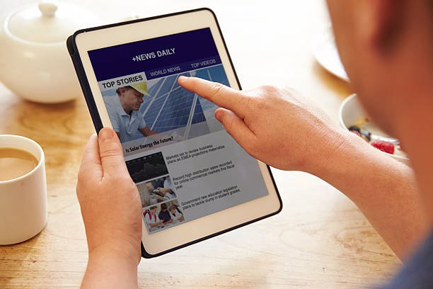 istock Person At Breakfast Looking At News App On Digital Tablet 486506992