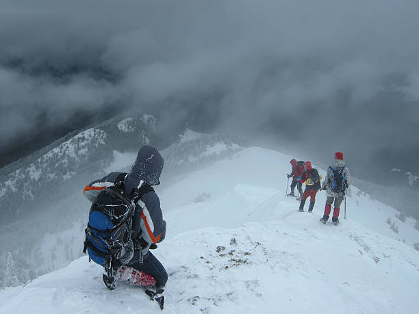 Climbers Entering The Snow Abyss stock photo