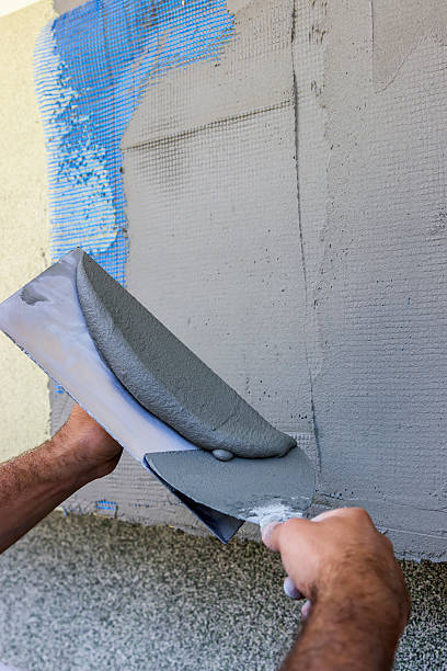 istock Facade plaster hand smoothing out wall with trowel 2 486507002