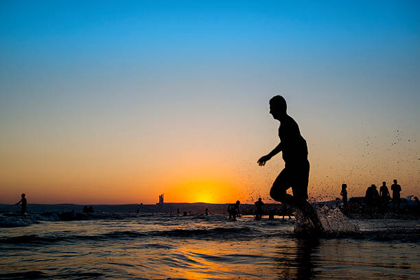 istock Man running on the beach at sunset 486507010