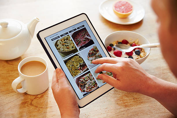Person At Breakfast Looking At Recipe App On Digital Tablet