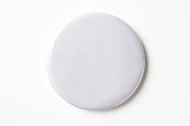 Overhead shot of blank white badge isolated on white background with clipping path.