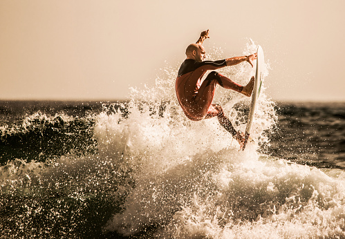 Young surfer having fun while riding a wave.
