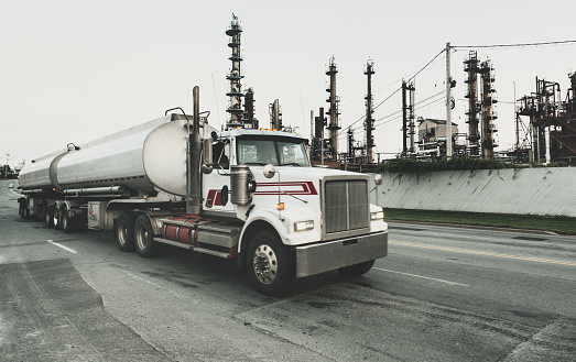 A semi tanker truck departs from an oil refinery.