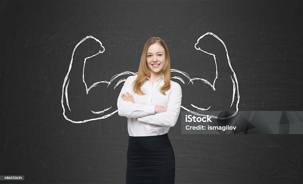 beautiful lady in formal clothes with drawn powerful hands A beautiful lady in formal clothes with drawn powerful hands. Black chalkboard background. Assertiveness Stock Photo