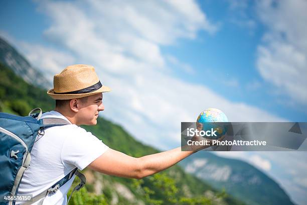 Man With Globe On Mountain Stock Photo - Download Image Now - 2015, Adult, Backpack