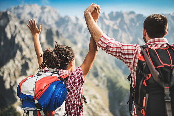 istock group of people standing on the mountain with arm raised 486522069