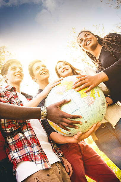 istock Group of teenagers holding an earth globe 486522467