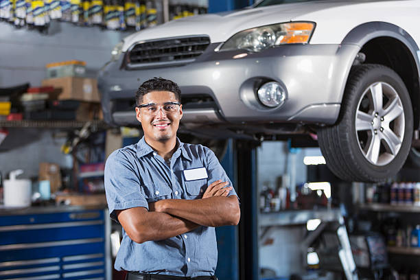 Auto mechanic Hispanic man (20s) working in auto repair shop. car mechanic top view stock pictures, royalty-free photos & images