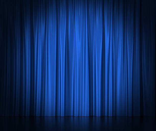 Blue silk curtains for theater and cinema spotlit light in stock photo