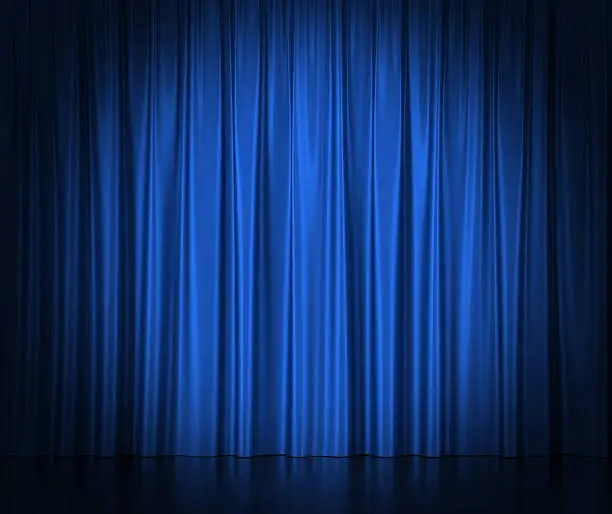 Photo of Blue silk curtains for theater and cinema spotlit light in