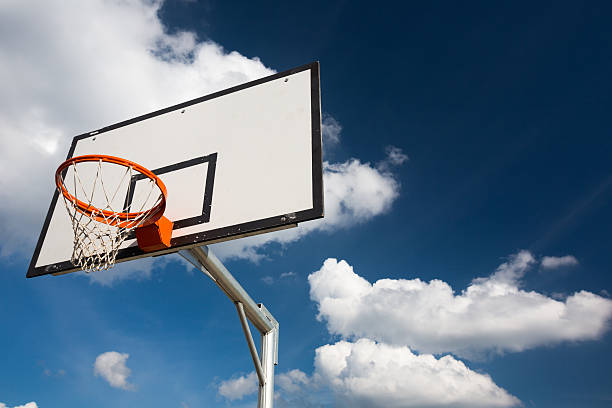 istock Basketball hoop against  lovely blue summer sky with some fluffy 486525373