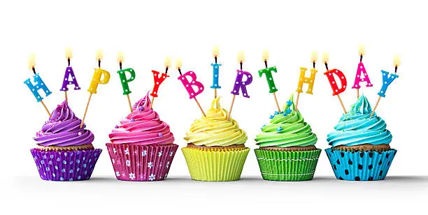 Row of colorful birthday cupcakes isolated on a white background