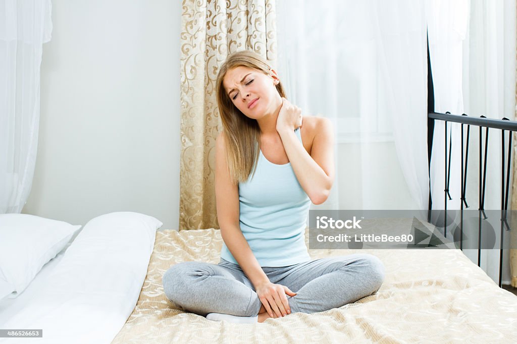 Neck pain Young woman  is having pain in her neck. Bed - Furniture Stock Photo