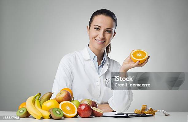 Dietician Holding An Orange Stock Photo - Download Image Now - Nutritionist, 2015, Adult
