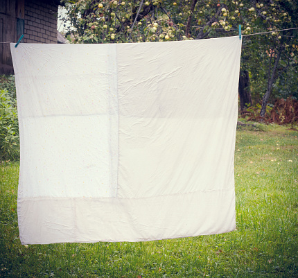 white washed duvet hanging in the yard