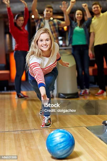 Happy Young Woman Throwing Ball In Bowling Club Stock Photo - Download Image Now - Ten Pin Bowling, People, Bowling Alley