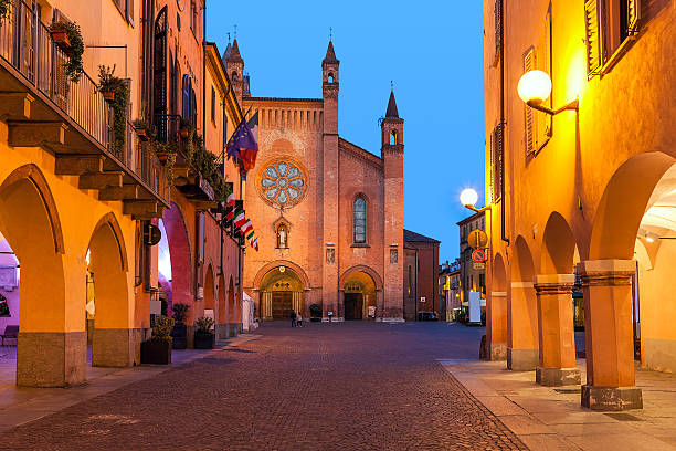 Old town of Alba in evening. Buildings, narrow cobblestone street and cathedral on background in old town of Alba in evening in Piedmont, Northern Italy. piedmont italy photos stock pictures, royalty-free photos & images