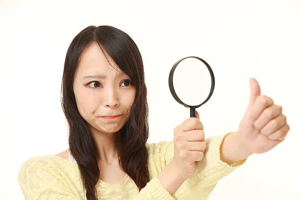 istock shocked young woman looking through a magnifying glass her nails 486534428