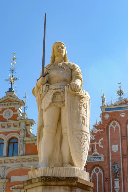Riga, Latvia- August 16, 2015:  Statue Of Roland In Riga at dusk With The House Of The Blackhead's And St. Peter's Church In The Background.