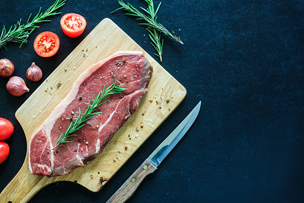 istock Raw meat and garnish on wood cutting board 486540352