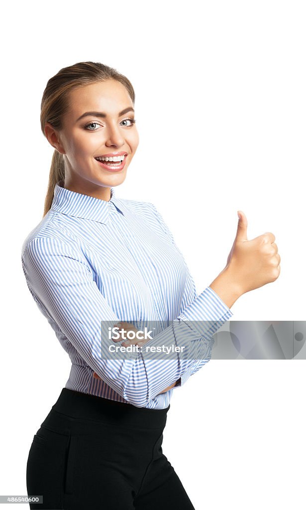 smiling woman showing thumbs up gesture Portrait of young happy smiling woman showing thumbs up gesture, over grey background 2015 Stock Photo