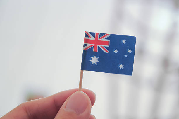 istock Mini Australian national flag holding by fingers 486546771