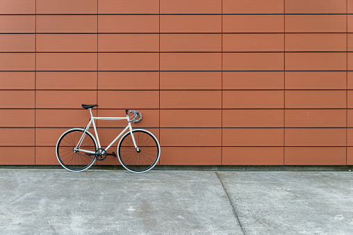 White fixie bike in orange wall