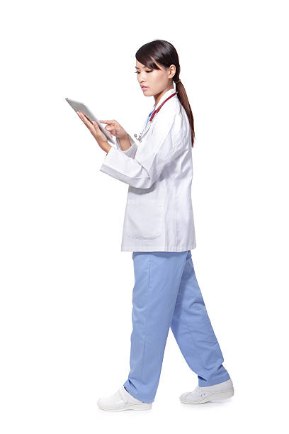 タブレット pc を使用して女性医師とウォーキング - chinese doctor ストックフォトと画像