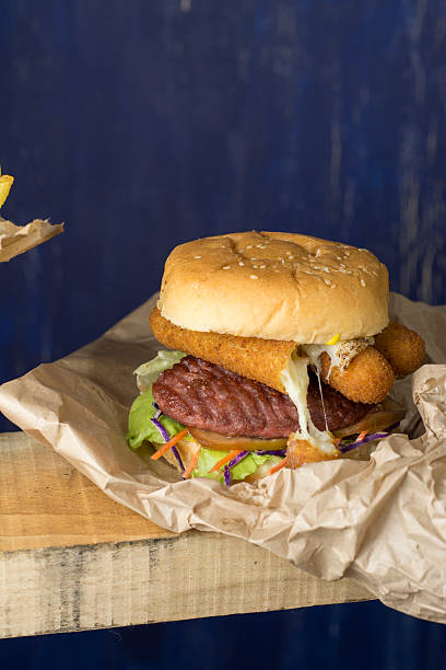 istock Hamburger, french fries in a paper wrapper , blue background 486547983