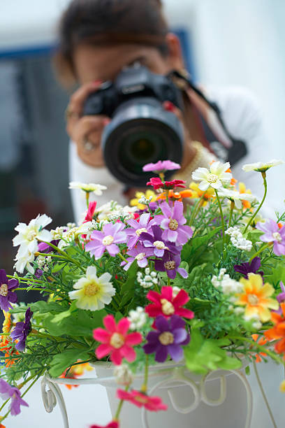girl take flower photo by camera