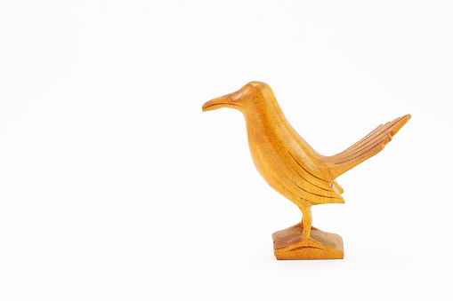 Wooden figurine of bird isolated on white background