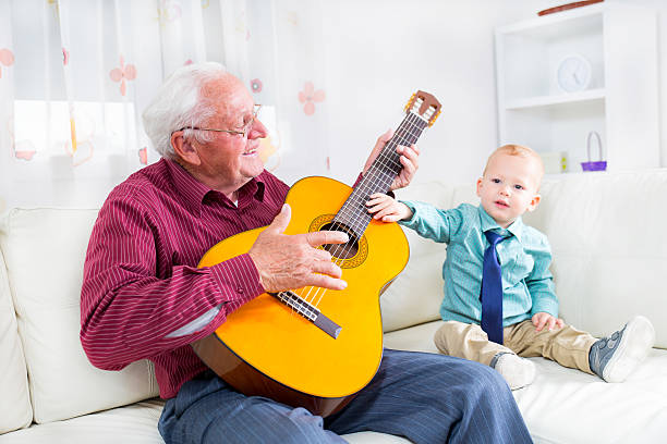 istock Grandfather playing the guitar to his grandson 486549893