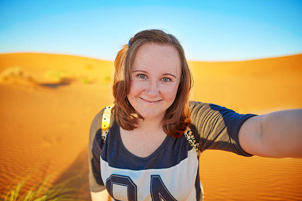 istock Happy smiling tourist taking selfie in Sahara desert 486550816
