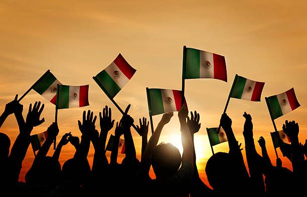 istock Group of People Waving Mexican Flags in Back Lit 486551946