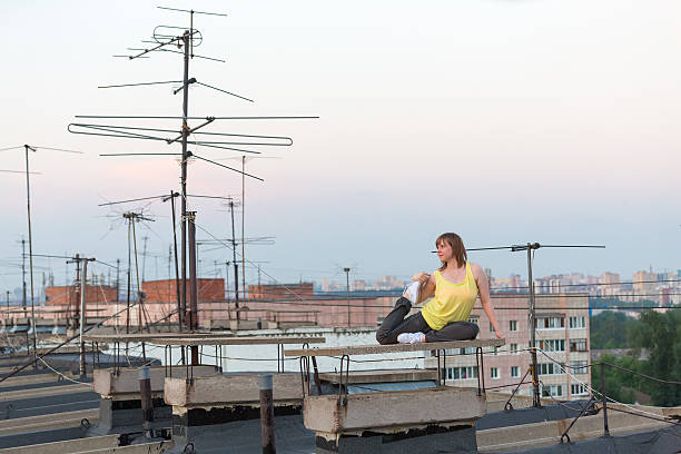 istock girl doing relaxing yoga exercises on roof 486552628