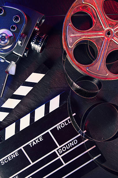istock Cinema clapboard and reel on black stone 486553694